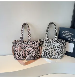 Macro view of leopard print tote bag textures and multiple functional zipper pockets