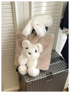 Close-up of brown plush tote bag with white fleece bear decor on a suitcase