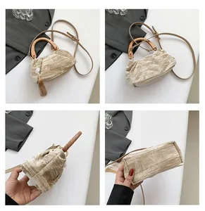 Detail view of champagne velvet handbag with wooden handle, tassel and shoulder strap