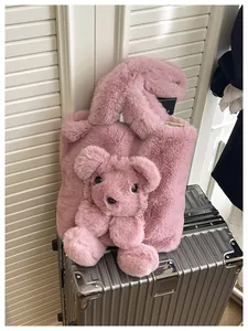 Close-up of pink fuzzy plush tote bag with a cute 3D bear on a silver suitcase