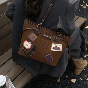 Sac cabas marron mat avec écussons de dessin animé et bandoulière sur un banc en bois