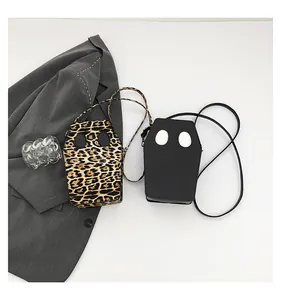 Detail of coffin-shaped crossbody bags in leopard print and black gothic style