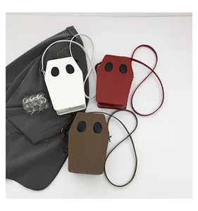 Flat lay of coffin-shaped ghost shoulder bags in white, red, and brown PU leather