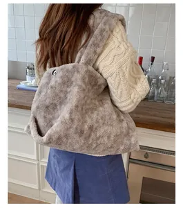 Detailed close-up of brown plush faux fur tote bag with wide shoulder strap on a model