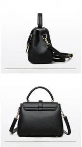 Detail view of black lychee grain leather handbag with adjustable strap and metal hardware