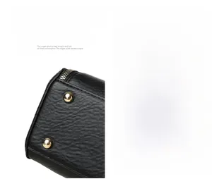 Detailed macro view of litchi texture black leather bag base with gold metal feet