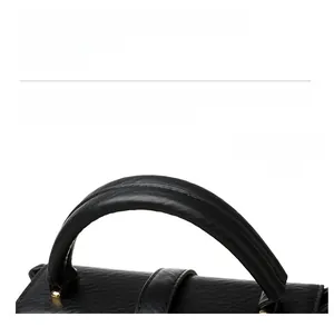 Detailed close-up of a black leather handbag handle with tight stitching and gold metal hardware