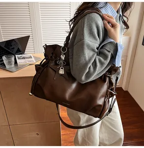 Vue détaillée du sac cabas en simili cuir marron foncé avec plis et logo argent
