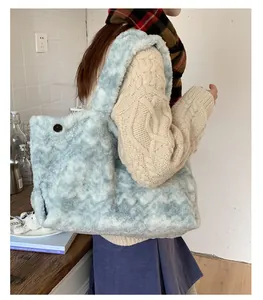 Detail view of light blue marble plush tote bag on shoulder with cozy winter styling