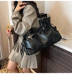 Détail du cabas en cuir ciré noir avec breloque étoile et fermeture coulissante