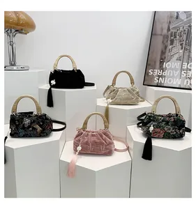 Detail of five vintage velvet and brocade handbags with tassels and wooden handles