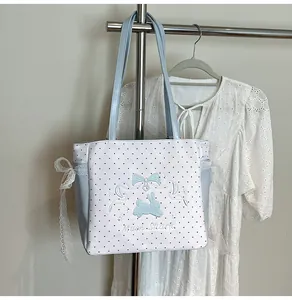 Détail du sac cabas à pois avec broderie lapin bleu et nœud en ruban de dentelle