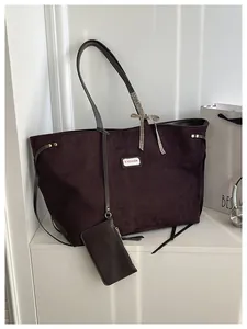 Detail der Wildleder-Einkaufstasche mit Fashion-Label und elegantem Karo-Seidenband