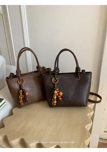 Detail of vintage leather tote bags with tassel charms and embossed fashion logo