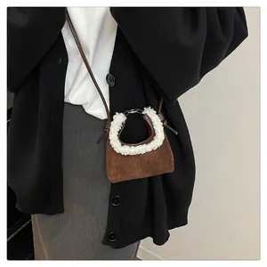 Close-up of brown suede bag with white faux fur trim and thin leather shoulder strap