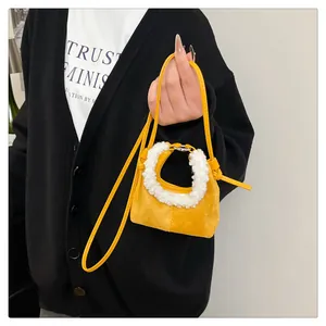 Detail of ginger suede dumpling bag with white faux fur trim and adjustable strap
