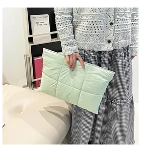 Handheld light green quilted laptop sleeve with soft waterproof fabric and zipper