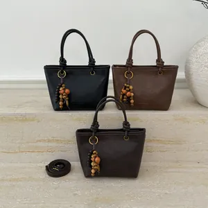 Vintage solid color leather bucket bag set in black and brown with beaded tassel detail