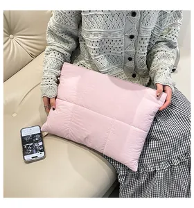Detail of light pink quilted laptop sleeve showing soft puffer texture and checkered pattern