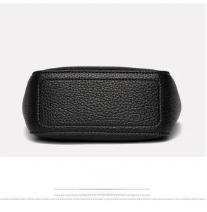 Detailed bottom view of a black lychee texture leather bucket bag with reinforced stitching