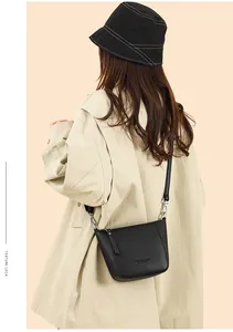 Rear view of model wearing black lychee texture bucket bag with silver metal hooks