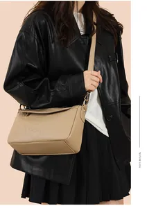 Détail du sac à bandoulière en cuir avec motif camélia gaufré et finitions dorées