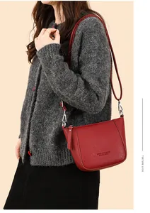 Detail of red lychee pattern bucket bag with silver hardware on model's shoulder