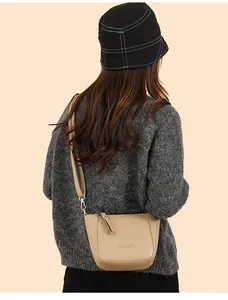 Detail of light brown lychee grain bucket bag on model with silver metal hooks