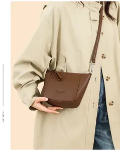 Close-up of brown litchi pattern leather bucket bag with silver metal zippers