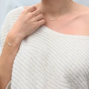 Detailed view of gold 18k plated necklace and bracelet set with natural pearls on a model