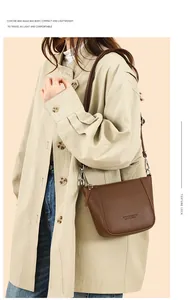 Dark brown lychee pattern leather bucket bag shown on model wearing beige trench coat