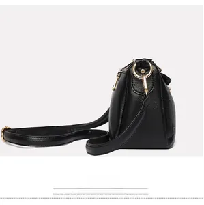 Détail du motif rose embossé sur le côté du sac en cuir noir à grain de litchi