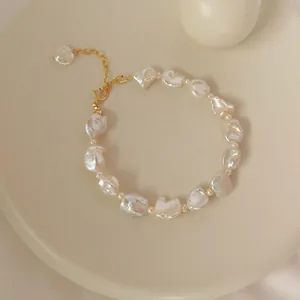 Dettaglio del bracciale di perle barocche irregolari con chiusura dorata e catena