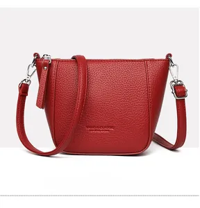Detailed front view of red litchi texture bucket bag with adjustable shoulder strap