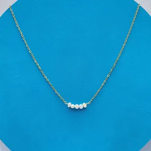 Detailed macro view of 18k gold plated chain featuring five natural freshwater pearls
