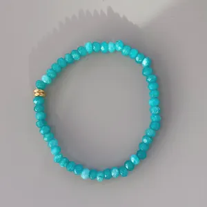 Detail view of faceted turquoise beads bracelet with decorative golden metal rings