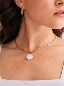 Detail of 18k gold paperclip chain necklace with a natural freshwater baroque pearl on a model