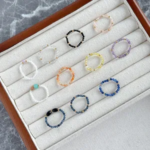 Handmade colorful natural stone beaded rings set with golden spacer beads in a box