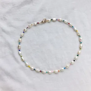 Detail of colorful beads and baroque pearls on necklace with gold lobster clasp