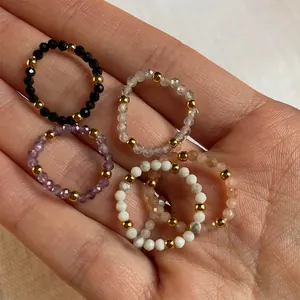 Macro detail of multi-color natural stone beaded elastic rings with gold metal accents