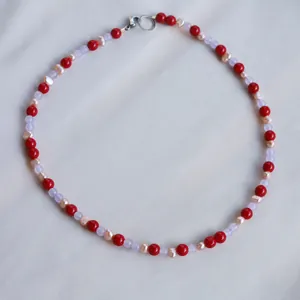 Dettaglio della collana con pietre rosse, perle rosa e chiusura a T in argento