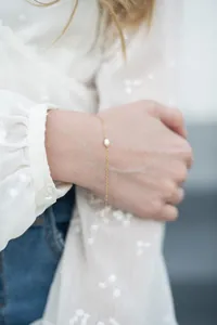 Close-up of minimalist 18k gold plated titanium chain necklace with a natural freshwater pearl
