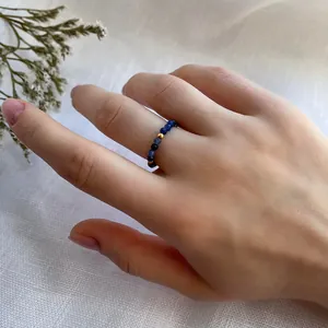 Detailed close-up of a handmade beaded ring featuring navy faceted stones and a gold bead