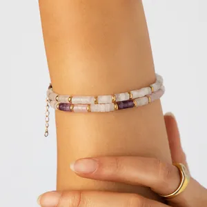 Primer plano de pulsera de doble capa con cuentas moradas y blancas en la muñeca