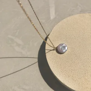 Detail of 18k gold plated necklace featuring a lustrous natural freshwater pearl pendant