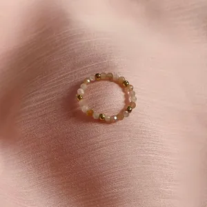 Detail of beaded ring with natural sunstone facets and gold spacers on silk