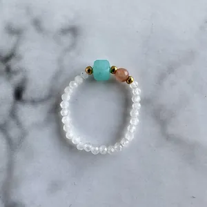 Macro view of a beaded ring with blue cube stone and white translucent crystals