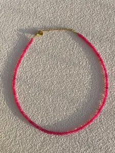 Macro shot of rose pink beaded necklace with 18k gold plated clasp and adjustable chain