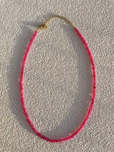 Macro detail of pink beaded necklace with 18k gold plated lobster clasp and extender