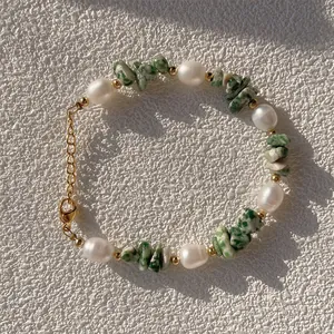 Détail du bracelet en perles d'eau douce et pierres vertes avec fermoir doré